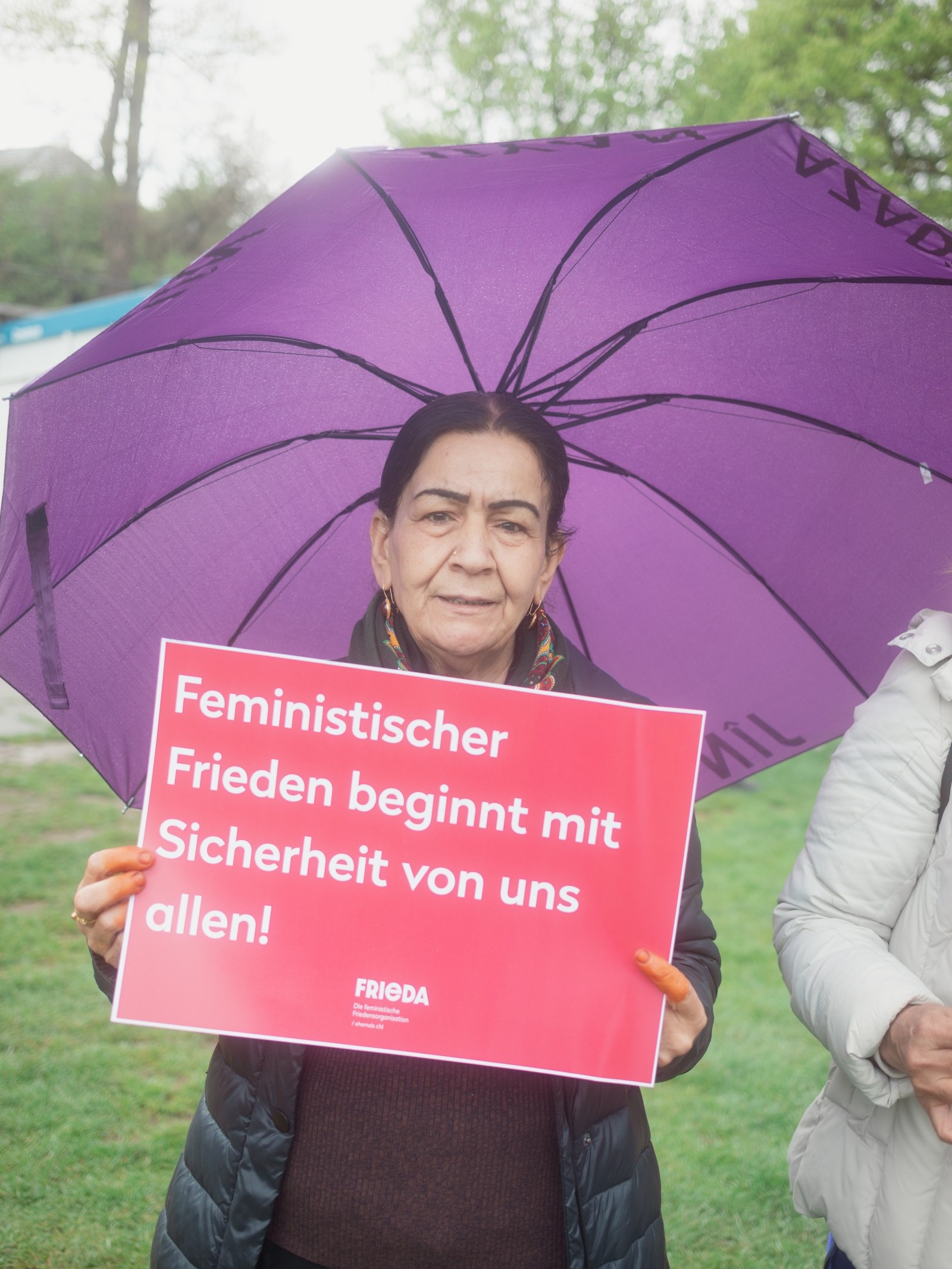 Frieda am Ostermarsch: Menschen marschieren mit Friedensflaggen und Schildern in Bern.
