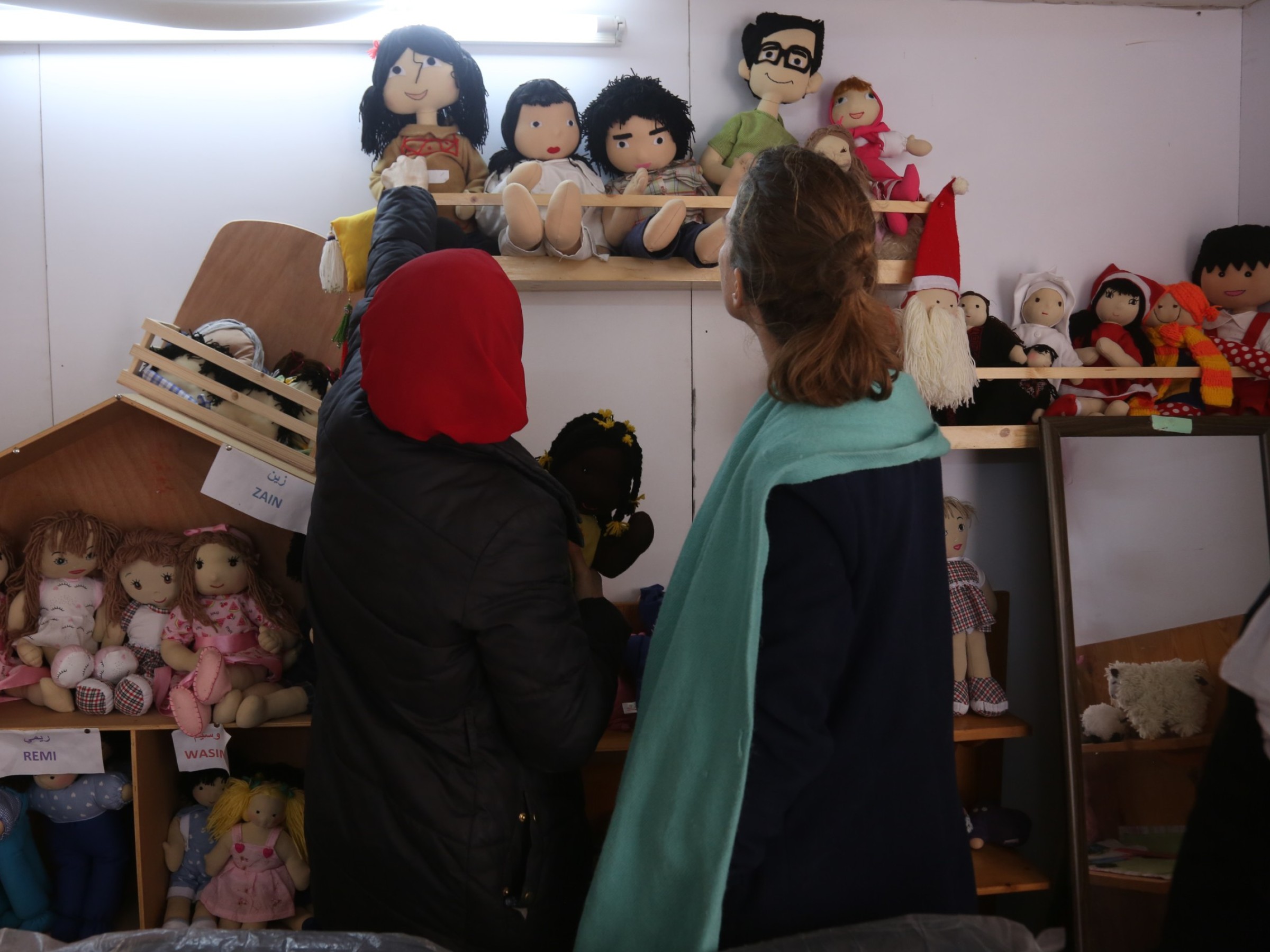 Frauen stehen vor Kinderspielsachen.