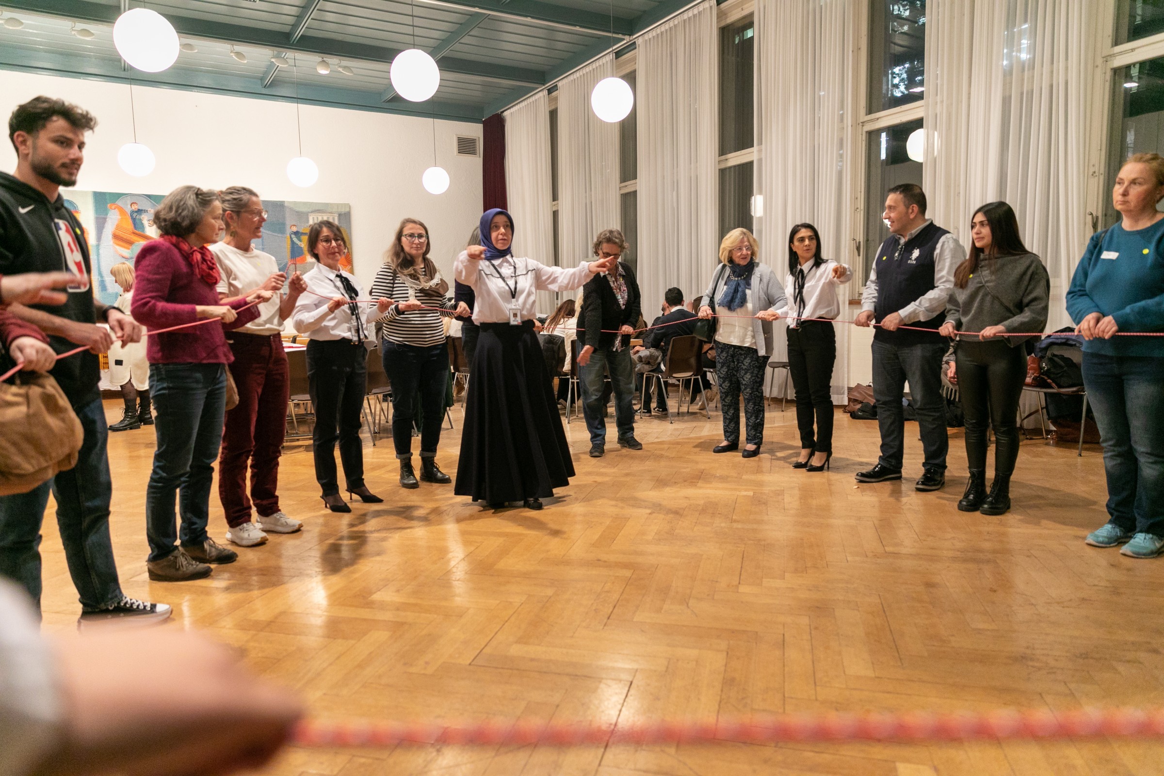 Menschen halten während einem Workshop eine Schnur im Kreis.