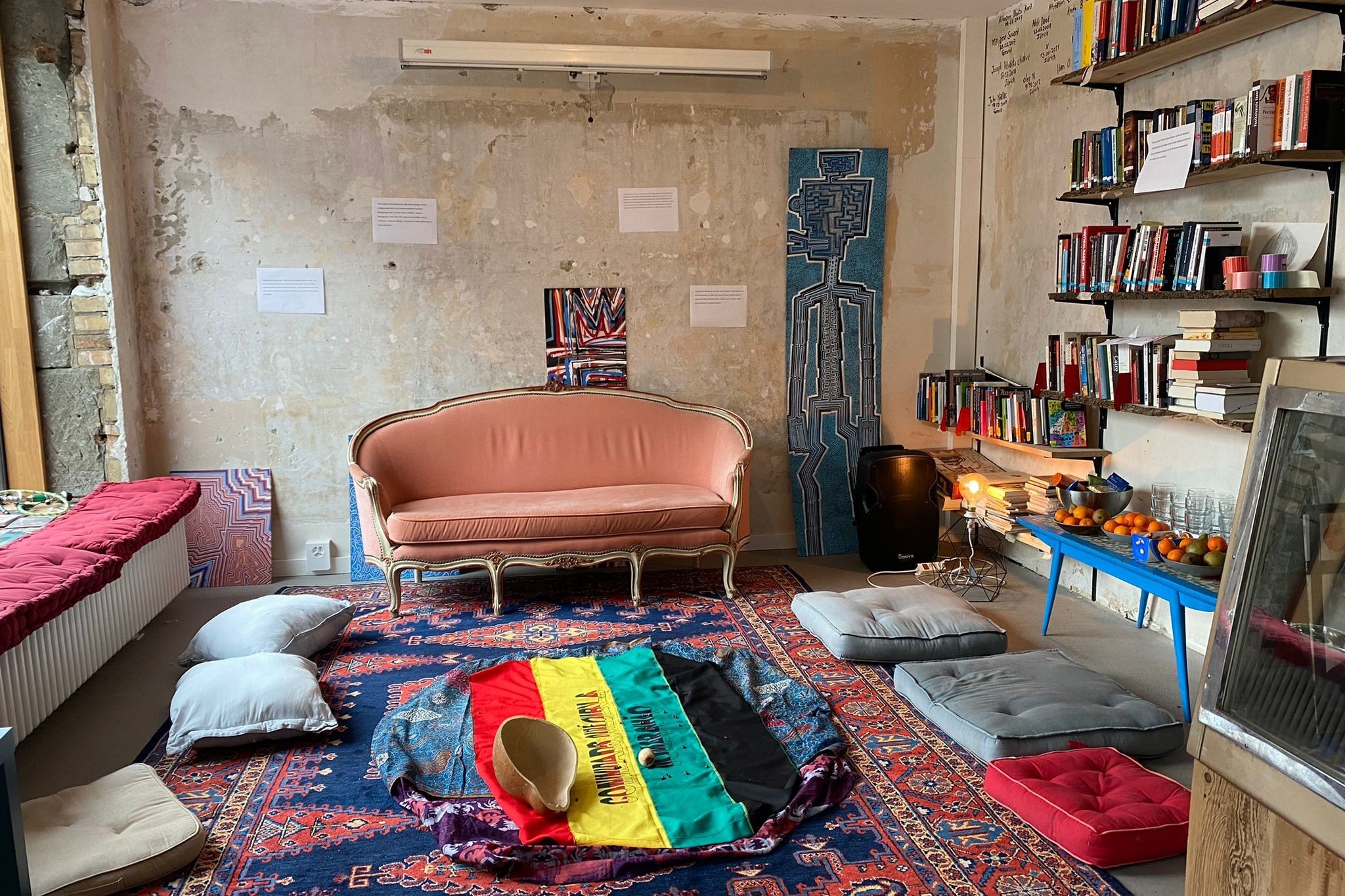 Der Living Room Bern vom Frieda-Projekt Oca: Wohnzimmer mit Kissen, Sofa und Büchern.
