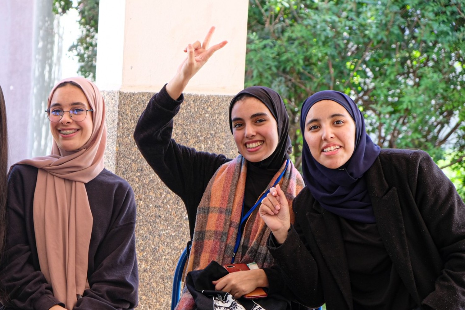 Vier junge Frauen in Marokko lachen und zeigen das Peace Zeichen mit den Fingern.