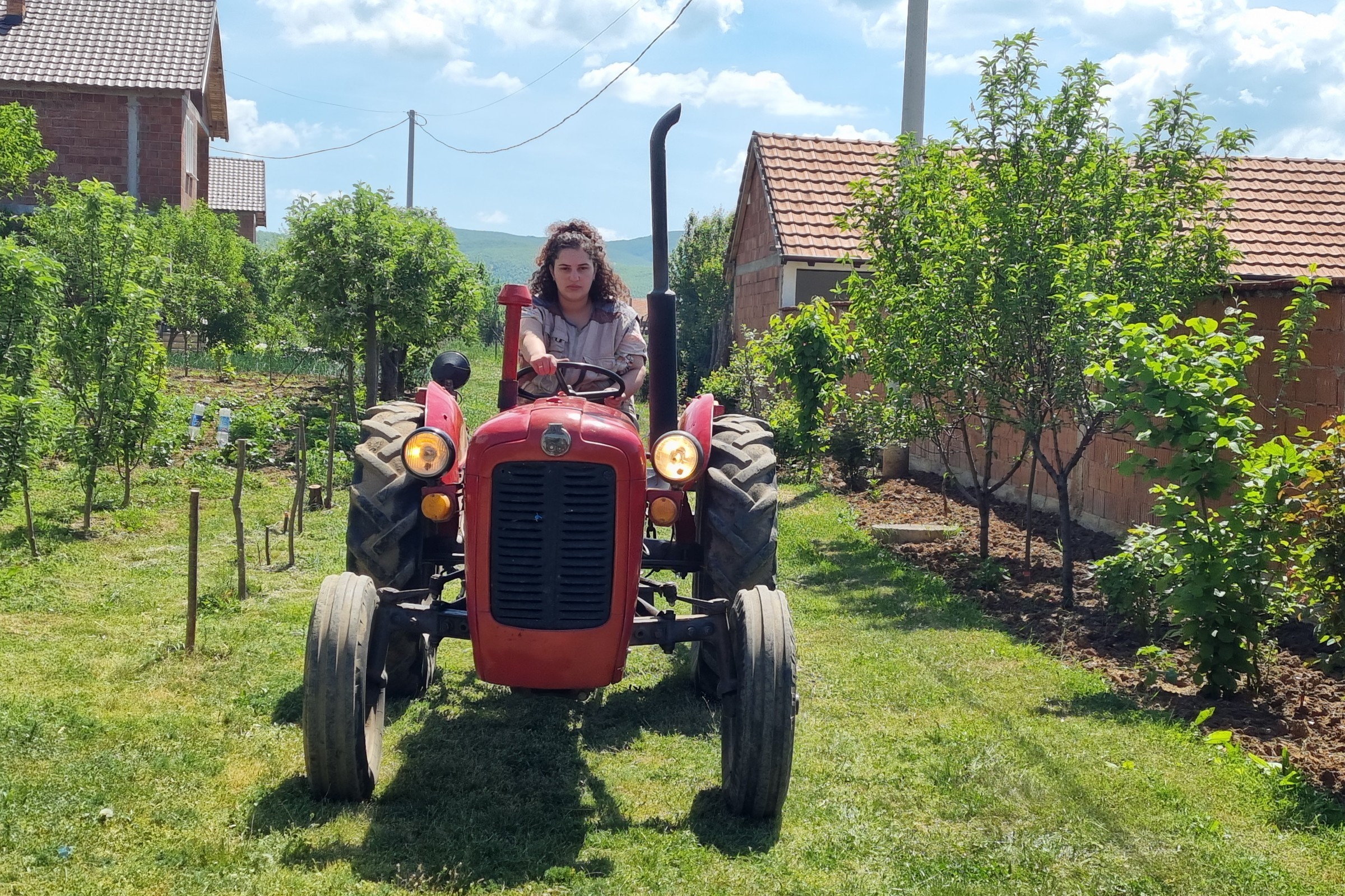 Eine Landwirtin in Kosovo auf dem Traktor.