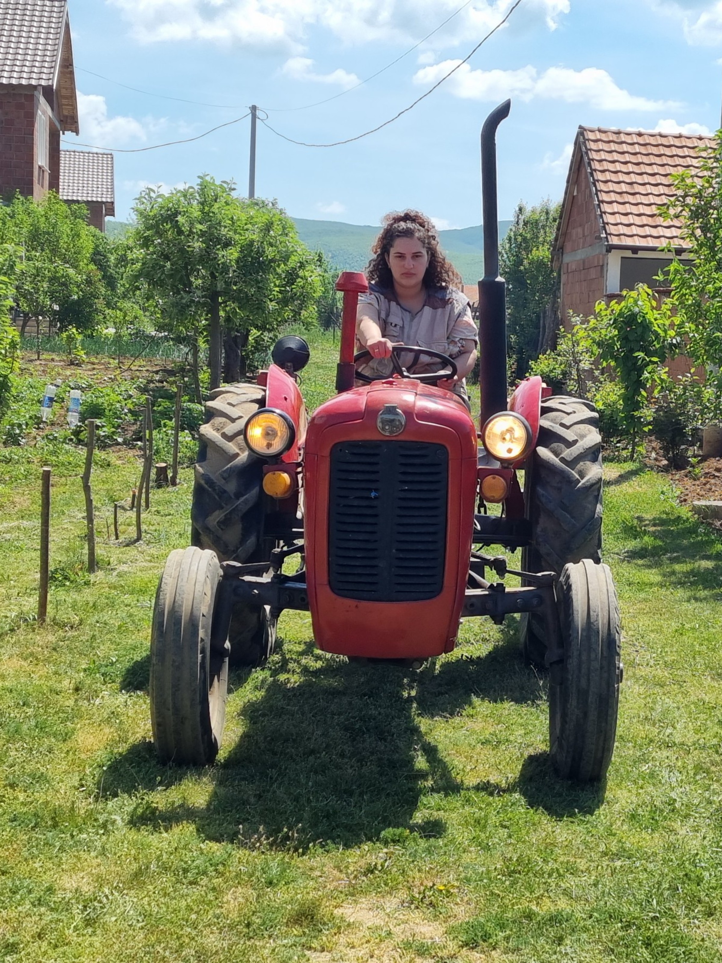 Eine Landwirtin in Kosovo auf dem Traktor.