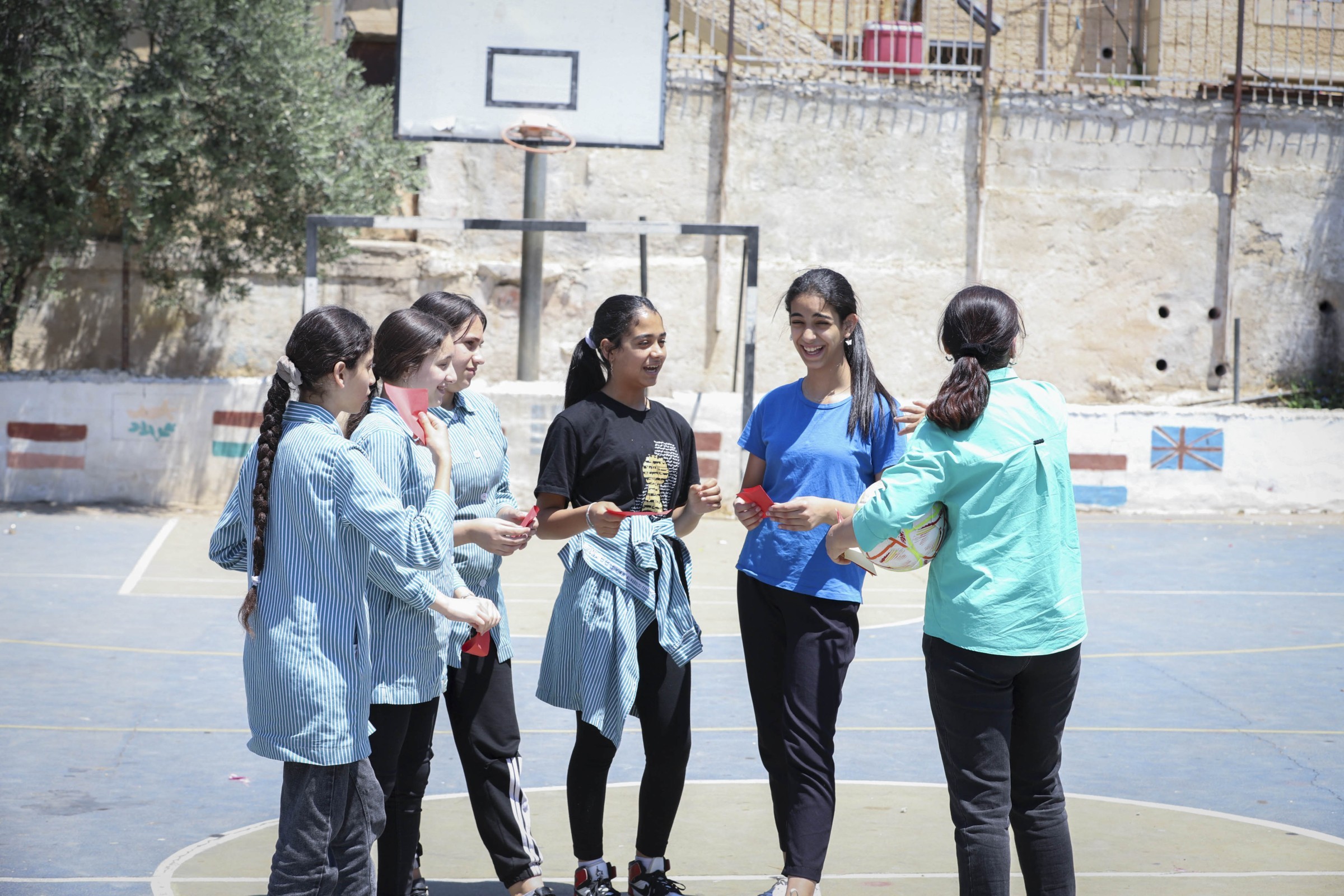 Mädchen in Palästina stehen mit einem Ball auf einem Sportplatz
