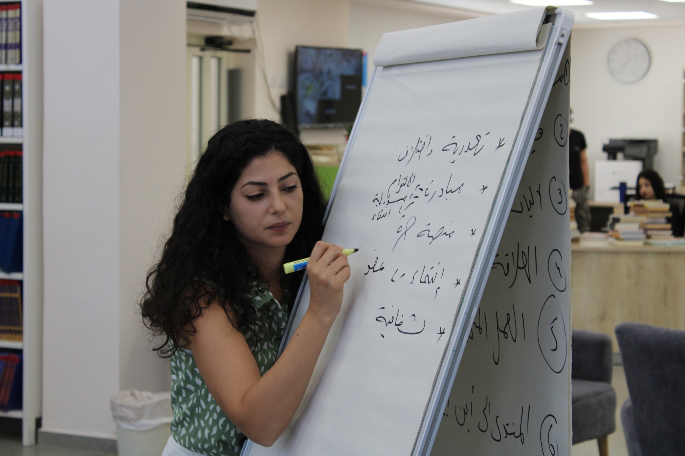 Palästinenserin in Israel schreibt auf ein Flipchart Board in arabischer Schrift