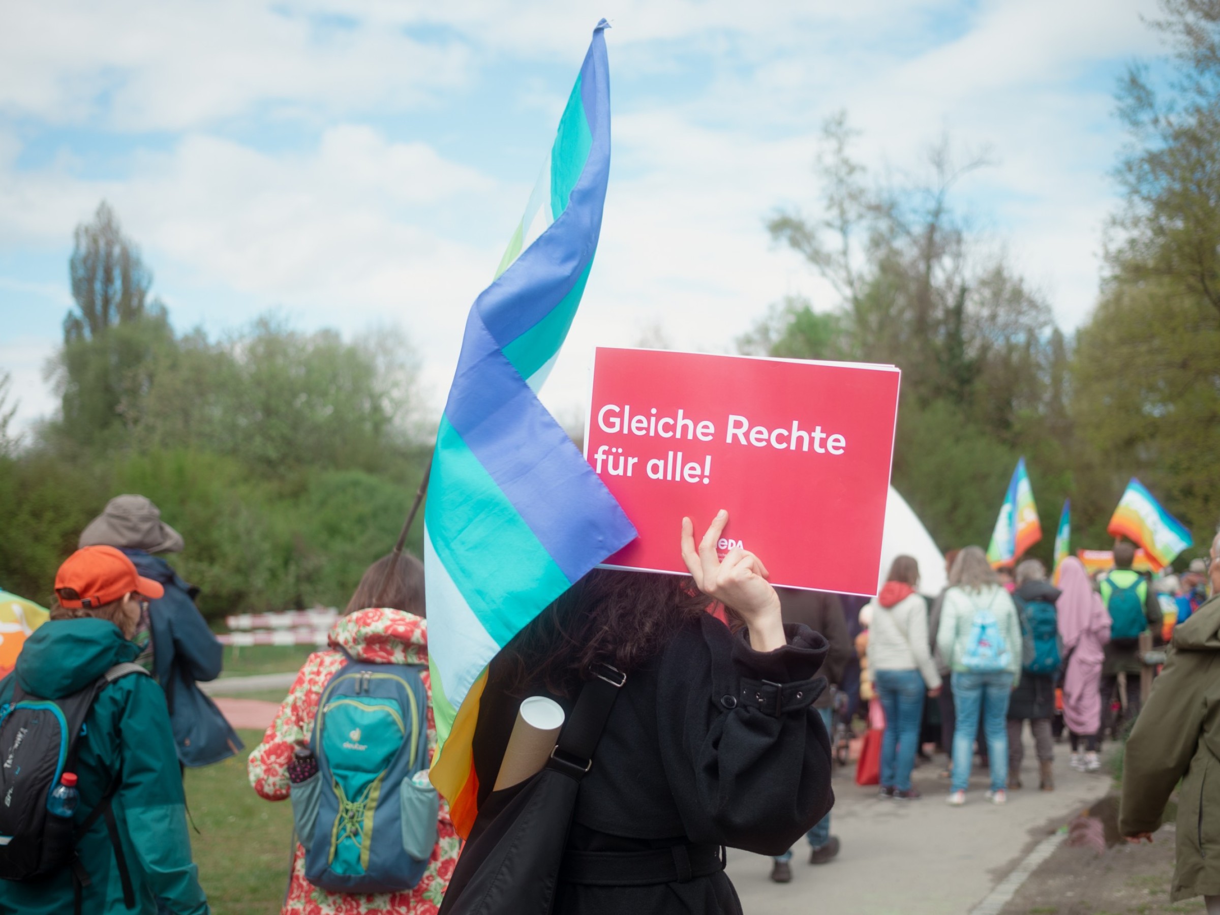 Frieda am Ostermarsch: Menschen marschieren mit Friedensflaggen und Schildern in Bern.